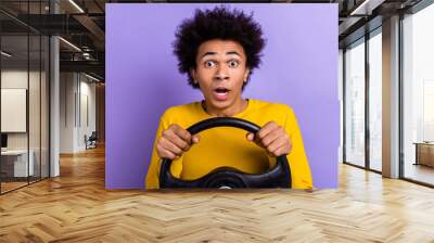 Photo of funny young driver guy hold his automobile steering wheel see car crash in front of him scared isolated on purple color background Wall mural