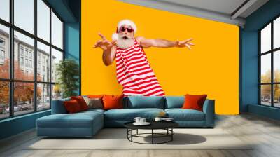 Photo of good mood carefree elderly guy wear new year swimsuit hat sunglass having disco fun empty space isolated yellow color background Wall mural