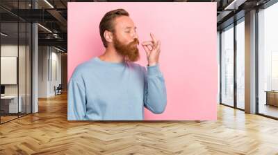 Photo of handsome cheerful man with ginger hairstyle dressed blue long sleeve tasting delicious food isolated on pink color background Wall mural