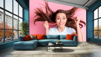 Photo of happy excited amazed crazy woman with flying hair raise fists in victory success isolated on pink color background Wall mural