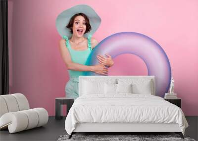 Photo of impressed brown hairdo young lady hold buoy wear hat teal top shorts isolated on pink color background Wall mural