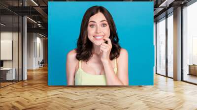 Photo of impressed tricky lady wear green outfit smiling finger lips isolated blue color background Wall mural