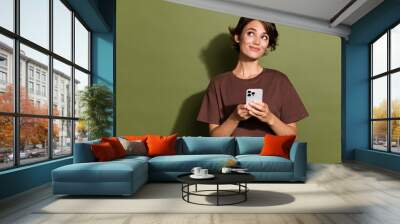 Photo of lovely lady look empty space instagram twitter facebook telegram wear trendy brown garment isolated on khaki color background Wall mural