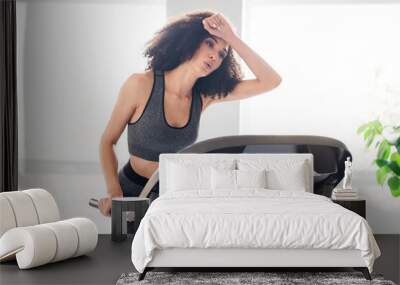 Photo of lovely tired sporty active girl runner doing physical exercises in gym daylight interior indoors Wall mural