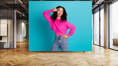 Photo of lovely young girl show v-sign eye tongue wear pink pullover isolated on teal color background Wall mural