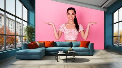 Photo of lovely young lady hold empty space wear top isolated on pink color background Wall mural