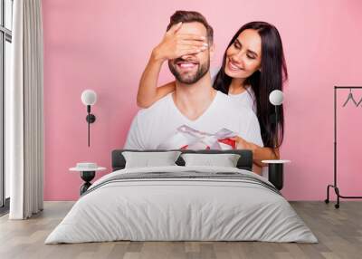 Photo of nice cute couple wearing white t-shirt of young people with girlfriend holding red package with bow congratulating his beloved one happy birthday while isolated with pink background Wall mural