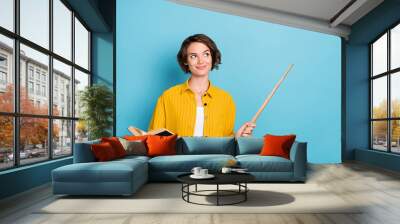 Photo of nice young brunette lady hold book wear yellow shirt isolated on blue color background Wall mural