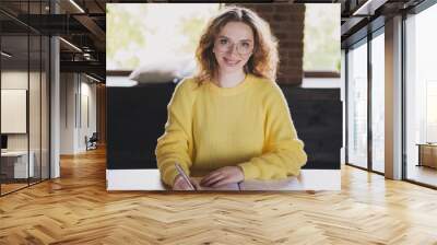 Photo of nice young woman write notebook dressed yellow sweater comfortable light startup office loft cozy room interior Wall mural