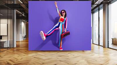 Photo of positive cool girl dancing active energetic with boom box pop music isolated on vivid color background Wall mural