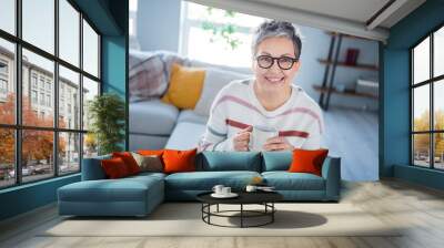 Photo of positive good mood woman dressed striped sweater eyewear enjoying tasty beverage indoors house home room Wall mural