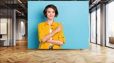 photo of positive lady indicate finger empty space discount wear yellow shirt isolated blue color ba Wall mural