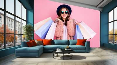 Photo of pretty millennial model lady carry many packs shopper enjoy tourism abroad sales wear fluffy jacket sun specs vintage blue hat isolated pink background Wall mural