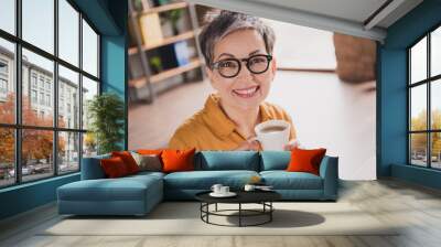 Photo of pretty retired woman drink coffee beverage dressed yellow formalwear modern workplace working home distance office Wall mural