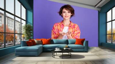 Photo of pretty young girl arms hold empty space wear shirt isolated on violet color background Wall mural