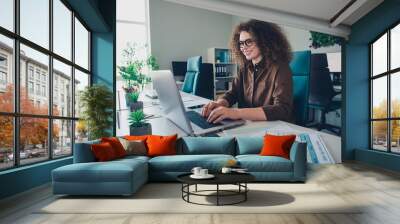 Photo of responsible charming successful woman working with modern device write news office indoors Wall mural