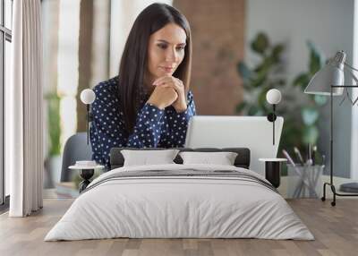 Photo of serious brown haired young business woman think look read laptop sit desk in office workplace workstation Wall mural