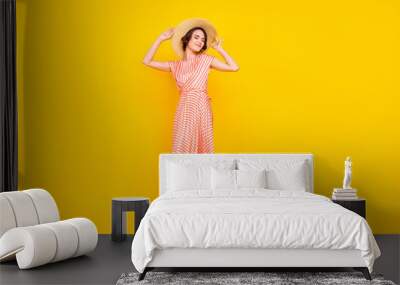 Photo of sincere peaceful girl enjoy vacation wear straw hat striped dress isolated yellow color background Wall mural