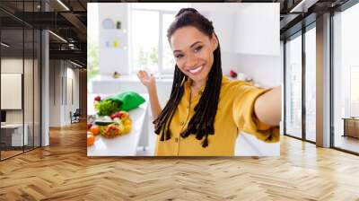 Photo of sweet adorable dark skin woman dressed yellow shirt braids inviting you cooking breakfast smiling indoors house home room Wall mural