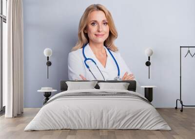 Photo of sweet confident mature lady doctor wear white coat arms crossed empty space isolated grey color background Wall mural