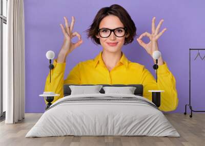 Photo of sweet millennial brunette lady show okey wear spectacles yellow blouse isolated on purple color background Wall mural