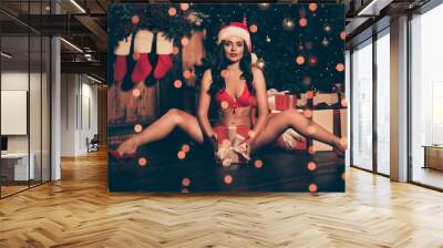 Photo of tender lady sit floor shiny smile hold box wear red underwear panties bra santa cap high-heels indoors Wall mural