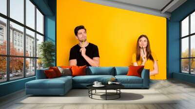 Photo of thoughtful guessing thinking couple of two people pondering over their new project being worked on by them as freelancers isolated over vivid color background in black t-shirt Wall mural