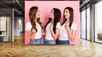 Photo of three young cheerful girls happy positive smile humor joke laugh look each others isolated over pink color background Wall mural