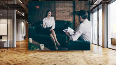 Photo of two business people lady man journalist drink coffee chatting friendly interview ask answer questions company ceo founder woman formalwear clothes sit couch modern office indoors Wall mural