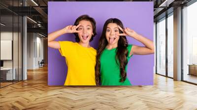 Photo of two little boy and girl make funny face tongue out show v-sign isolated on purple color background Wall mural