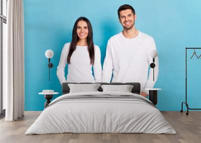 Photo of two nice positive people hold arms toothy smile isolated on blue color background Wall mural