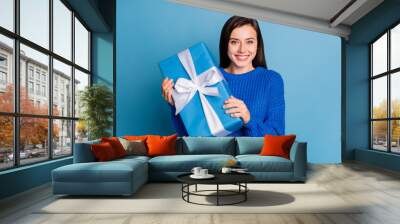 Photo of young attractive lovely happy positive girl smiling hold new year present isolated on blue color background Wall mural