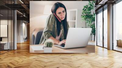 Photo of young attractive lovely pretty unhappy upset sad woman in glasses talk phone working in laptop at home house Wall mural