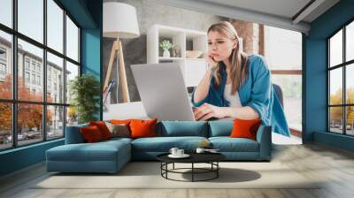 Photo of young bored working business lady wearing blue shirt at her workplace with laptop remote job freelancer in living room loft house indoors Wall mural