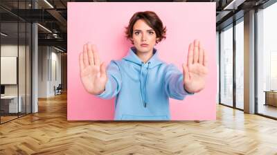 Photo of young funny serious attractive perfect woman wear blue hoodie showing no hands because taboo isolated on pink color background Wall mural