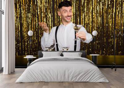 Photo of young handsome man barman happy positive smile propose cocktail you isolated over glitter color background Wall mural