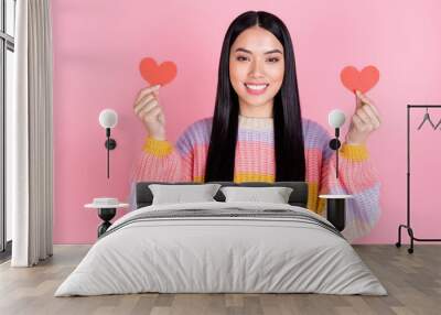 Photo of young happy positive smiling girl hold two little paper hearts celebrate valentine day isolated on pink color background Wall mural