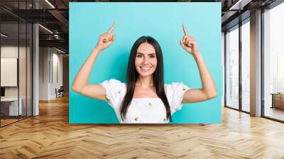 Photo of young nice woman model wearing white trendy crop top direct fingers up useful tips promoting isolated on cyan color background Wall mural