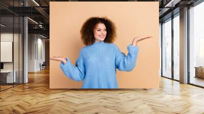 Photo of young saleswoman promoting your perspective investment option holding arms advantage isolated on beige color background Wall mural