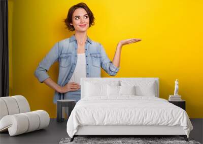 Photo of young woman demonstrate promo ads suggest advertise look empty space isolated over yellow color background Wall mural