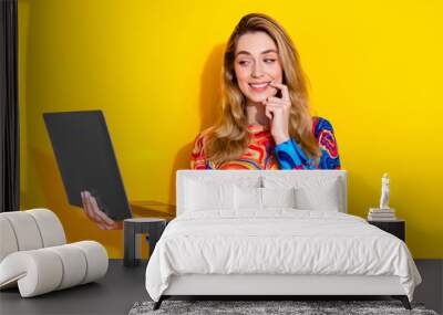 Photo portrait of attractive young woman hold netbook minded look dressed stylish colorful clothes isolated on yellow color background Wall mural