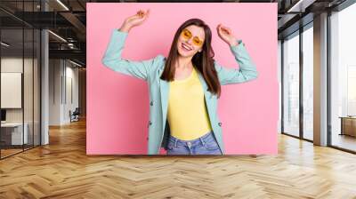 Photo portrait of carefree woman dancing with closed eyes isolated on pastel pink colored background Wall mural