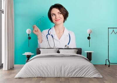 Photo portrait of cheerful female doctor wearing white coat looking empty space isolated bright teal color background Wall mural