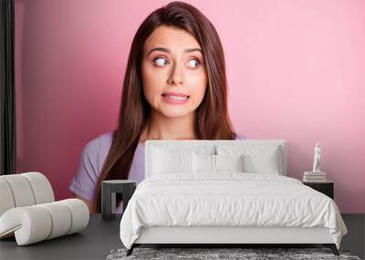 Photo portrait of clumsy girl isolated on pastel pink colored background Wall mural