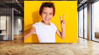 Photo portrait of cute little boy take selfie v-sign dressed stylish white clothes isolated on yellow color background Wall mural