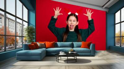 Photo portrait of cute little girl goofy excited playful dressed green christmas clothes theme party on red color background Wall mural