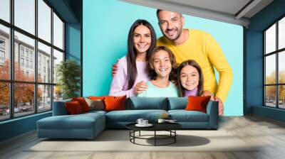 Photo portrait of full family with small kids smiling hugging isolated on vivid cyan colored background Wall mural