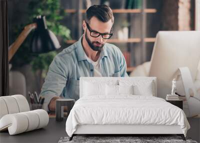 Photo portrait of guy writing in notebook working on pc at table in modern industrial office indoors Wall mural