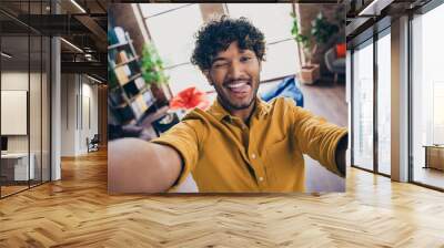 Photo portrait of handsome young guy wear yellow shirt selfie photo stick tongue wink funky stylish room interior home office design Wall mural