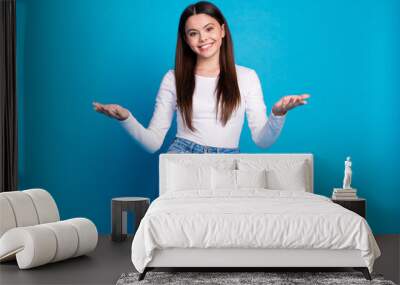 Photo portrait of lovely teen lady stretch hands welcome dressed stylish white garment isolated on blue color background Wall mural